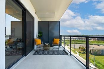 A balcony with a chair and a table